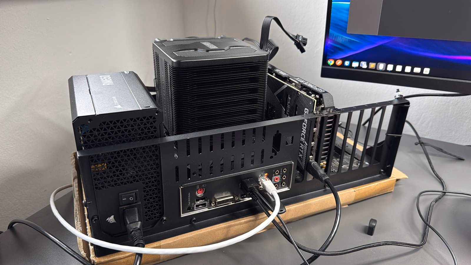 Offener Prüfstandaufbau des Servers auf einem Schreibtisch: Netzteil, großer Luftkühler auf dem Prozessor, Grafikkarte und Mainboard-Anschlüsse frei zugänglich.